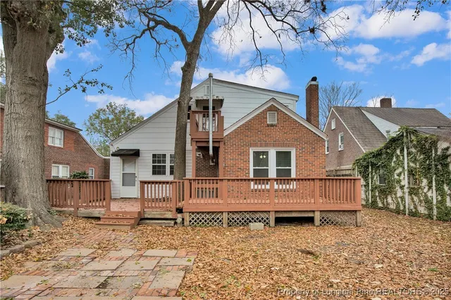 a front view of a house with a yard and trees