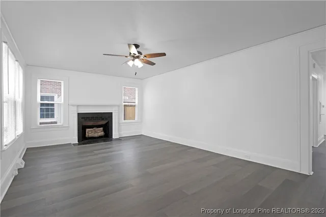 a view of an empty room with a fireplace and a window