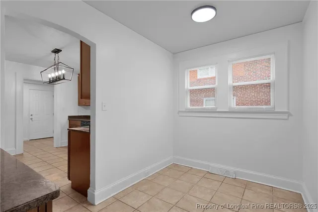 an empty room with wooden floor sink and mirror