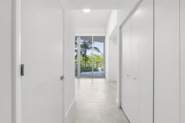 a view of a hallway with wooden floor and a potted plant