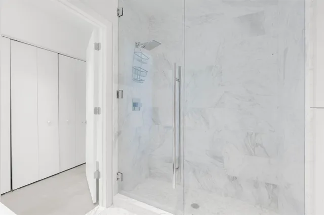 an empty room with glass door and shower