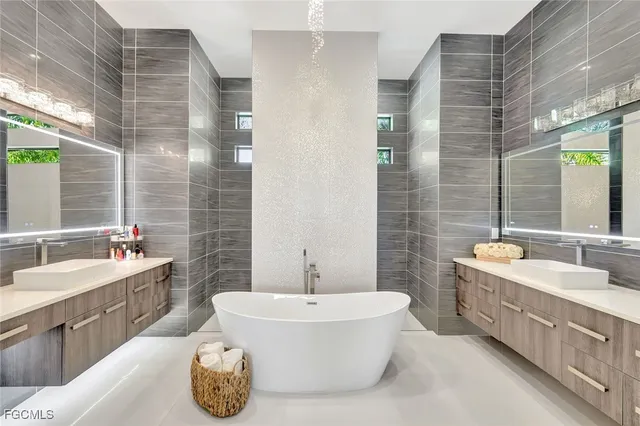 a bathroom with a tub double vanity sink and mirror