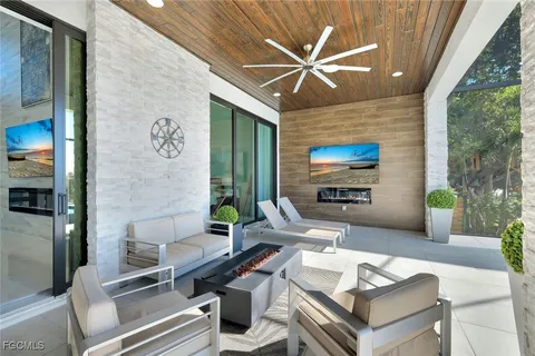 a living room with furniture a flat screen tv and a large window