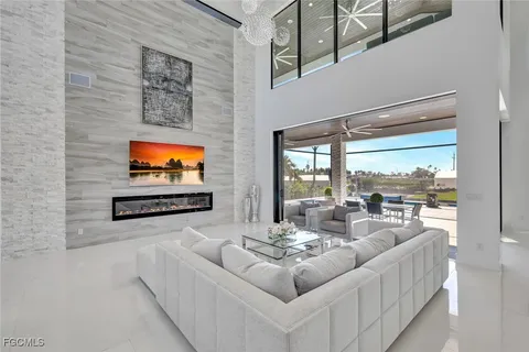 a living room with furniture a flat screen tv and a floor to ceiling window
