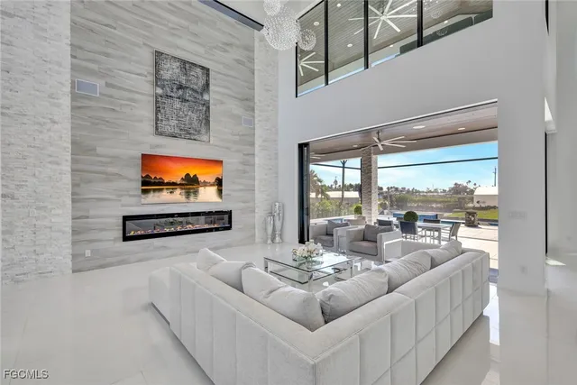 a living room with furniture a flat screen tv and a floor to ceiling window