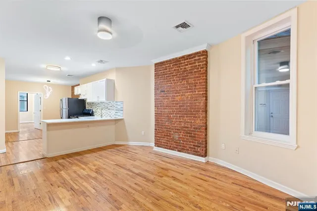 a view of kitchen with wooden floor and electronic appliances