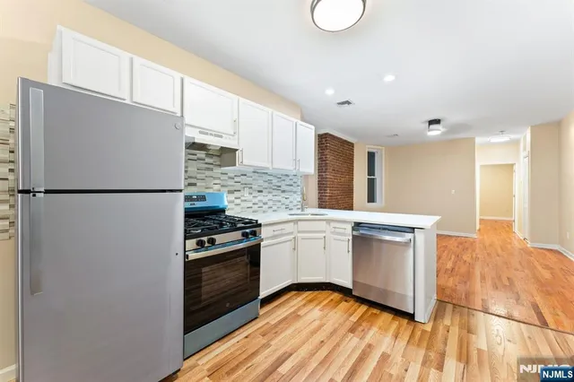 a kitchen with stainless steel appliances granite countertop a refrigerator sink and stove
