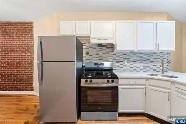 a kitchen with cabinets appliances and a counter space