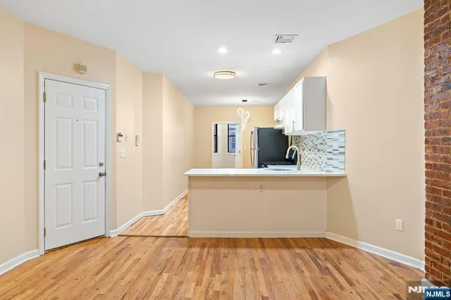 a view of kitchen with stainless steel appliances wooden floor
