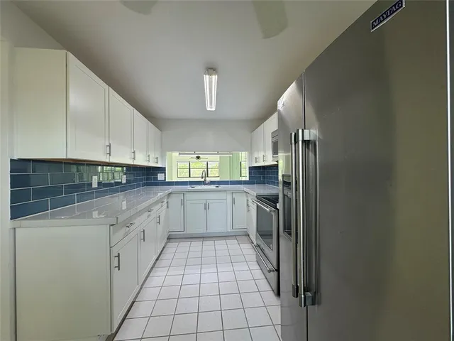 a kitchen with a sink and white cabinets