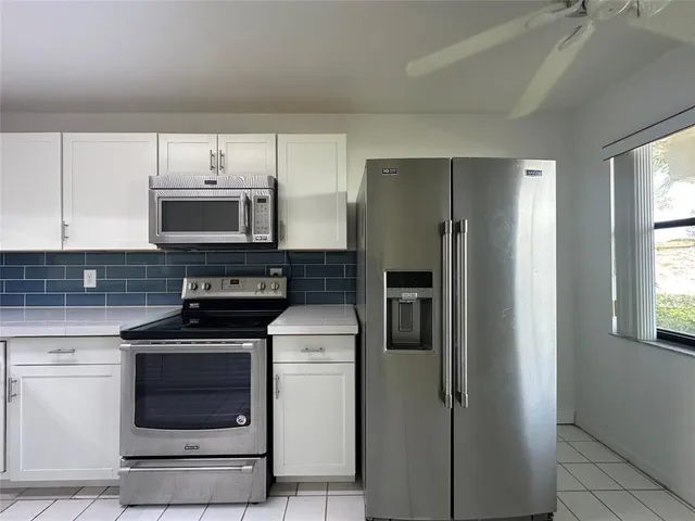 a kitchen with cabinets stainless steel appliances and a window