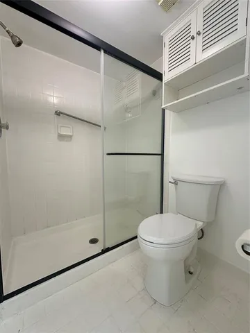 a bathroom with a toilet and a shower