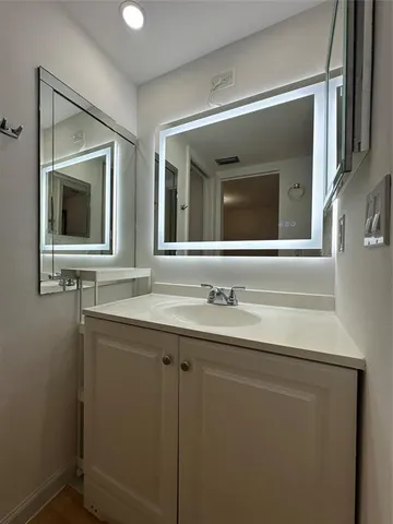 a bathroom with a granite countertop sink mirror and vanity