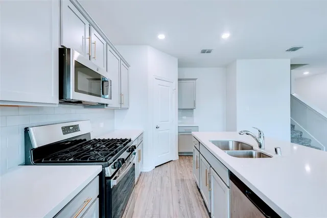 a kitchen that has a sink and a stove top oven