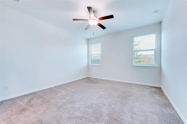 an empty room with a window and a ceiling fan