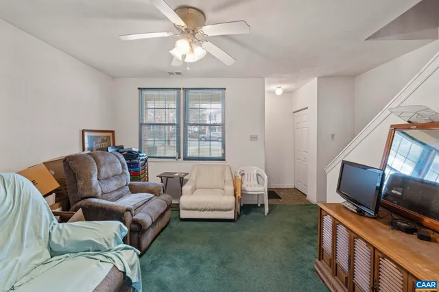 a living room with furniture a flat screen tv and a window