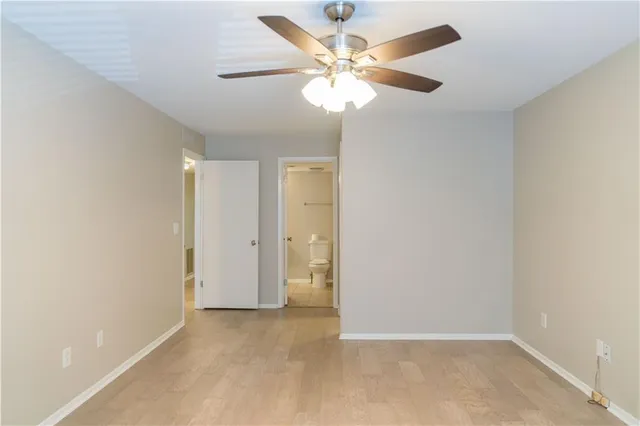 an empty room with a window and a fan