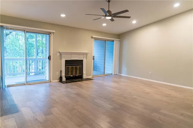 an empty room with fireplace fan and windows