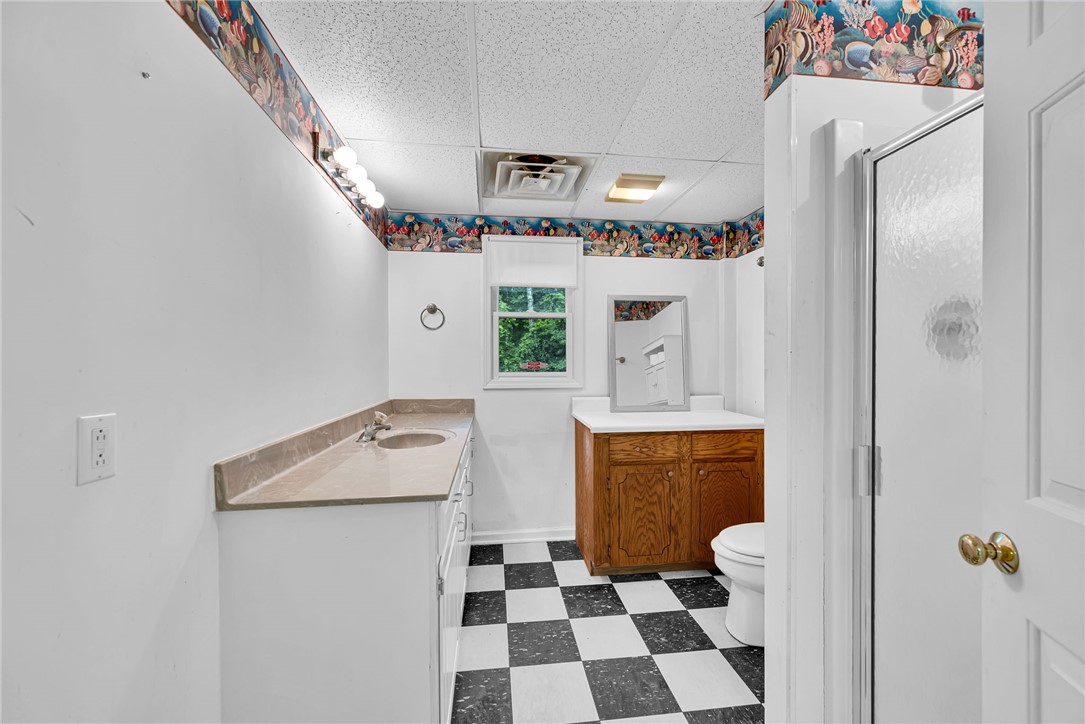 1016 Campbell Road Belton, SC 29627 - Photo 28 of 50 A well-lit bathroom featuring a checkered floor, vanity, and a window.