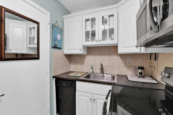 a kitchen with stainless steel appliances granite countertop a sink a stove and cabinets