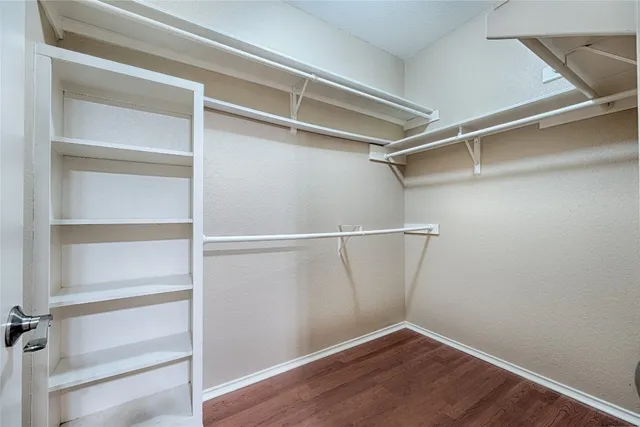 a view of walk in closet with empty racks
