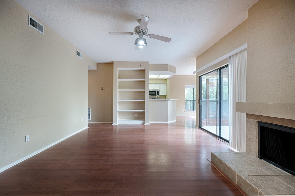 4711 Spicewood Springs Road, Unit 173 Austin, TX 78759 - Photo 4 of 19 a view of a livingroom with wooden floor a ceiling fan and windows