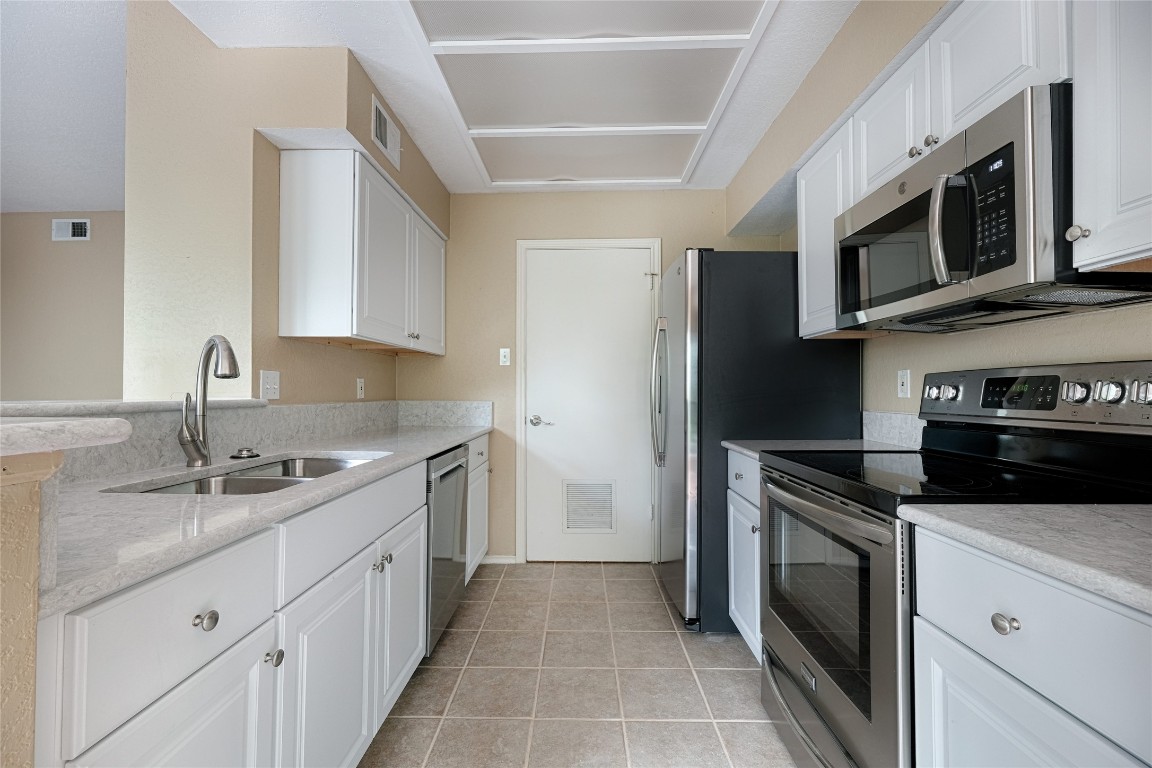 4711 Spicewood Springs Road, Unit 173 Austin, TX 78759 - Photo 9 of 19 a kitchen with stainless steel appliances granite countertop a sink stove and refrigerator