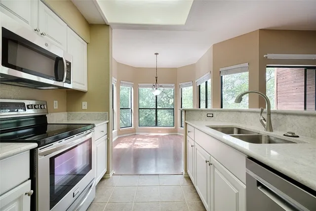 a kitchen with stainless steel appliances granite countertop a stove and a microwave