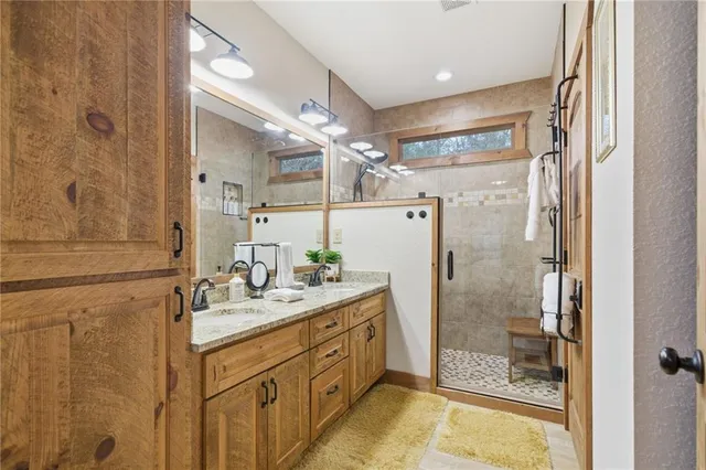 a bathroom with a double vanity sink mirror and shower