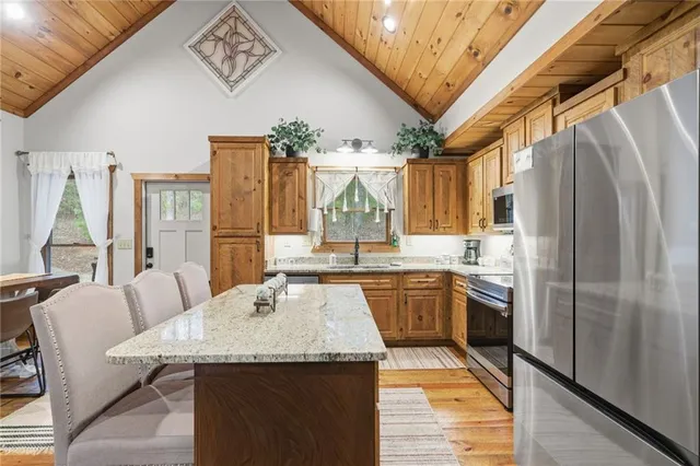 a kitchen with stainless steel appliances granite countertop a sink a stove and refrigerator