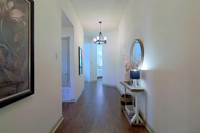 a view of a room with gym equipment and wooden floor