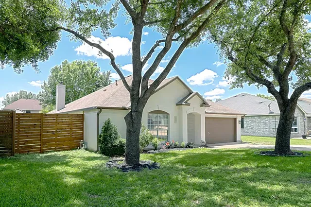 a front view of a house with a garden and yard