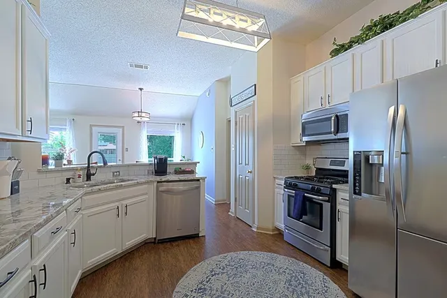 a kitchen with a sink stainless steel appliances and cabinets