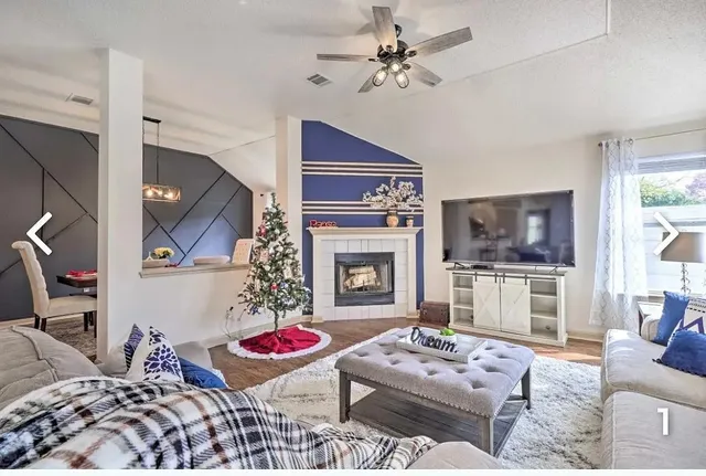 a living room with furniture a flat screen tv and a fireplace