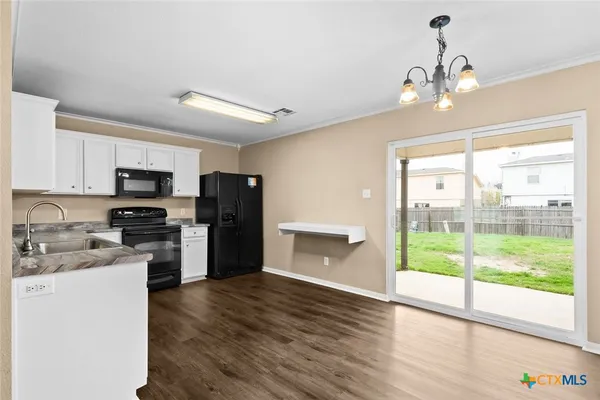 a kitchen with a refrigerator a stove top oven a sink and dishwasher with wooden floor