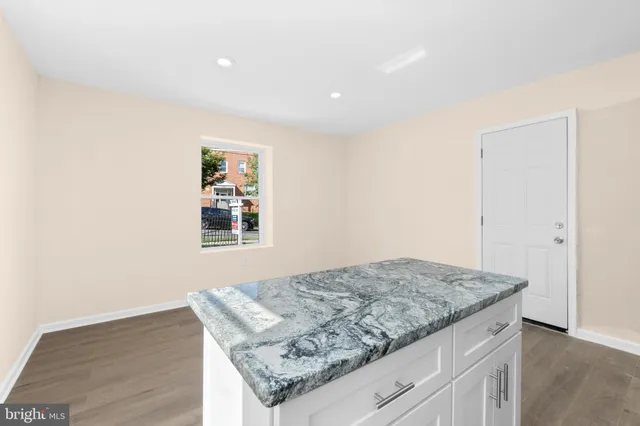 an empty room with wooden floor and window