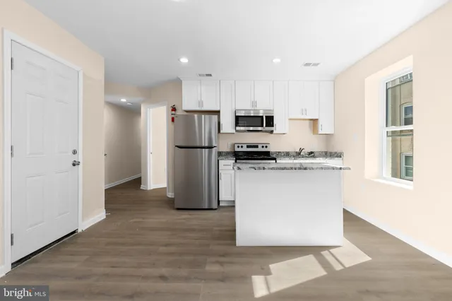 a kitchen with a refrigerator and a stove top oven