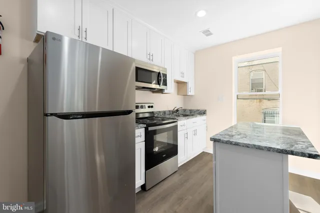a kitchen with a refrigerator and a stove top oven