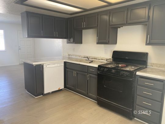 201 South Sunset Street Ridgecrest, CA 93555 - Photo 9 of 20 a kitchen with stainless steel appliances granite countertop a stove and a refrigerator