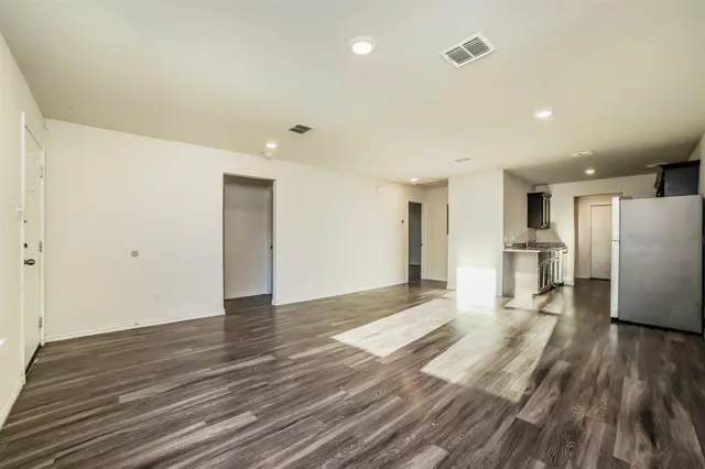 a view of a kitchen with wooden floor and a refrigerator