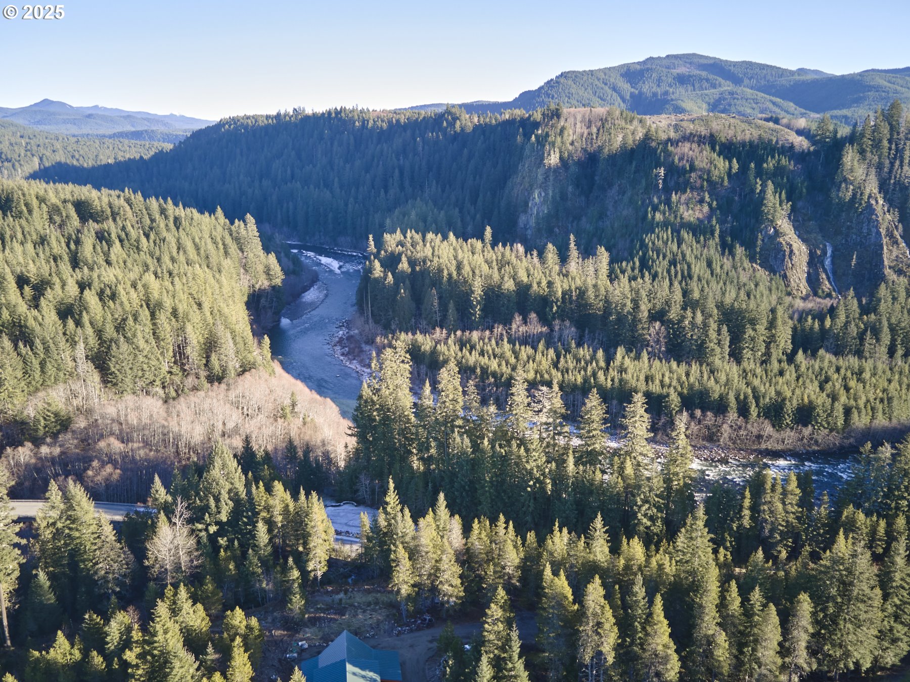 a view of a house with a yard and mountain view in back