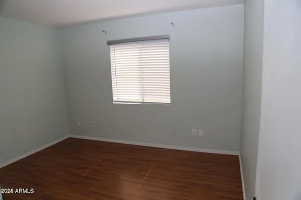 an empty room with wooden floor and a window