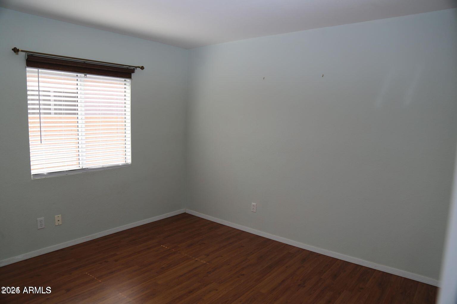 2228 East Aire Libre Avenue Phoenix, AZ 85022 - Photo 16 of 24 a view of an empty room with wooden floor and a window