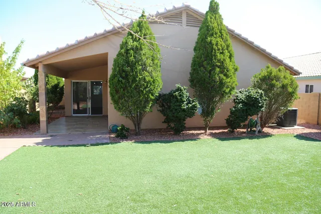 front view of a house with a yard and potted plants