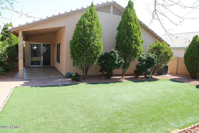 a view of a house with backyard and a tree