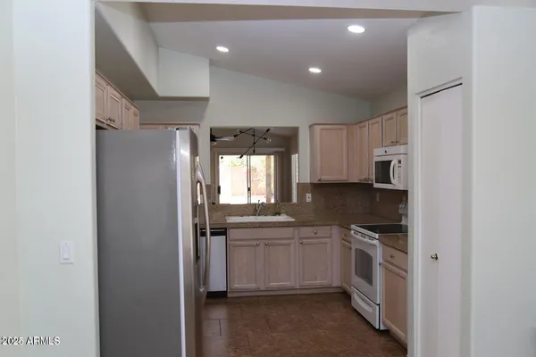 a kitchen with white cabinets and white appliances