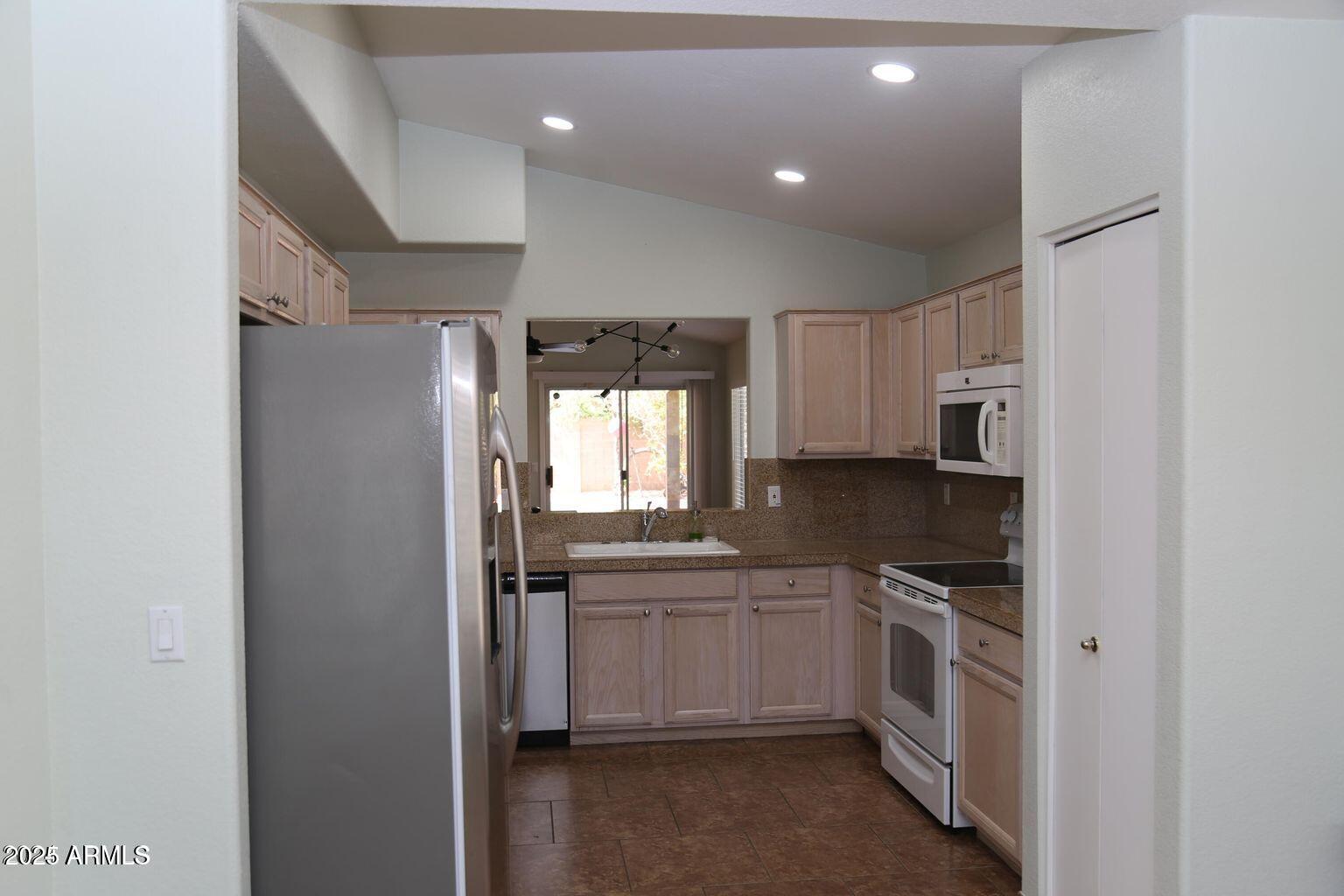 2228 East Aire Libre Avenue Phoenix, AZ 85022 - Photo 3 of 24 a kitchen with white cabinets and white appliances