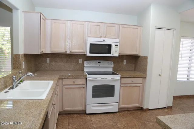 a kitchen with white cabinets sink and white appliances