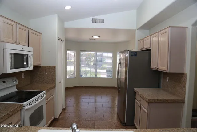 a kitchen with stainless steel appliances granite countertop a refrigerator a stove a sink and a microwave