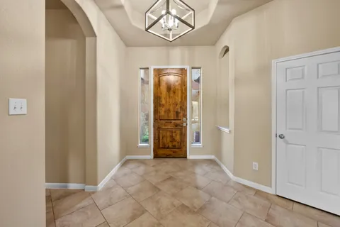 an empty room with chandelier fan and closet area
